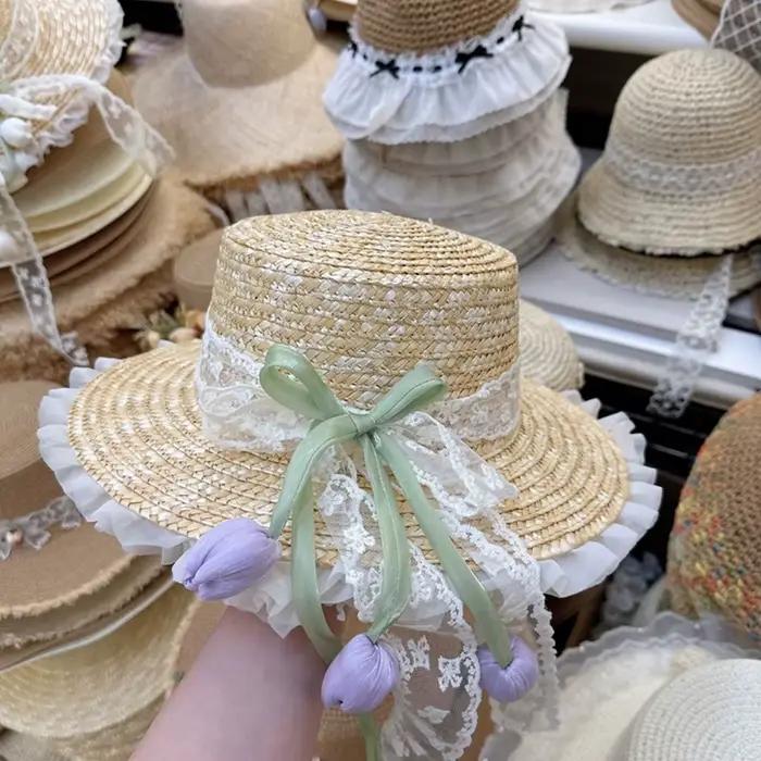 Chapeau de paille à large bord avec nœud en dentelle et fleur