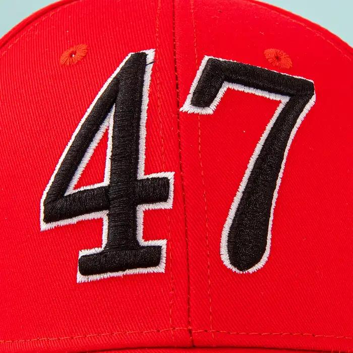 Casquettes rouges et blanches avec « 47 » : debout contre le drapeau américain